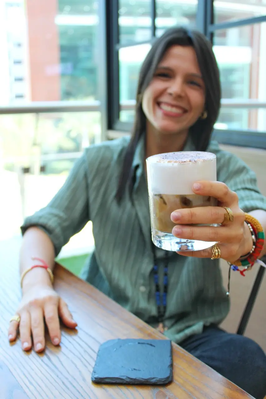 Gaby sonríe y acerca una taza de café