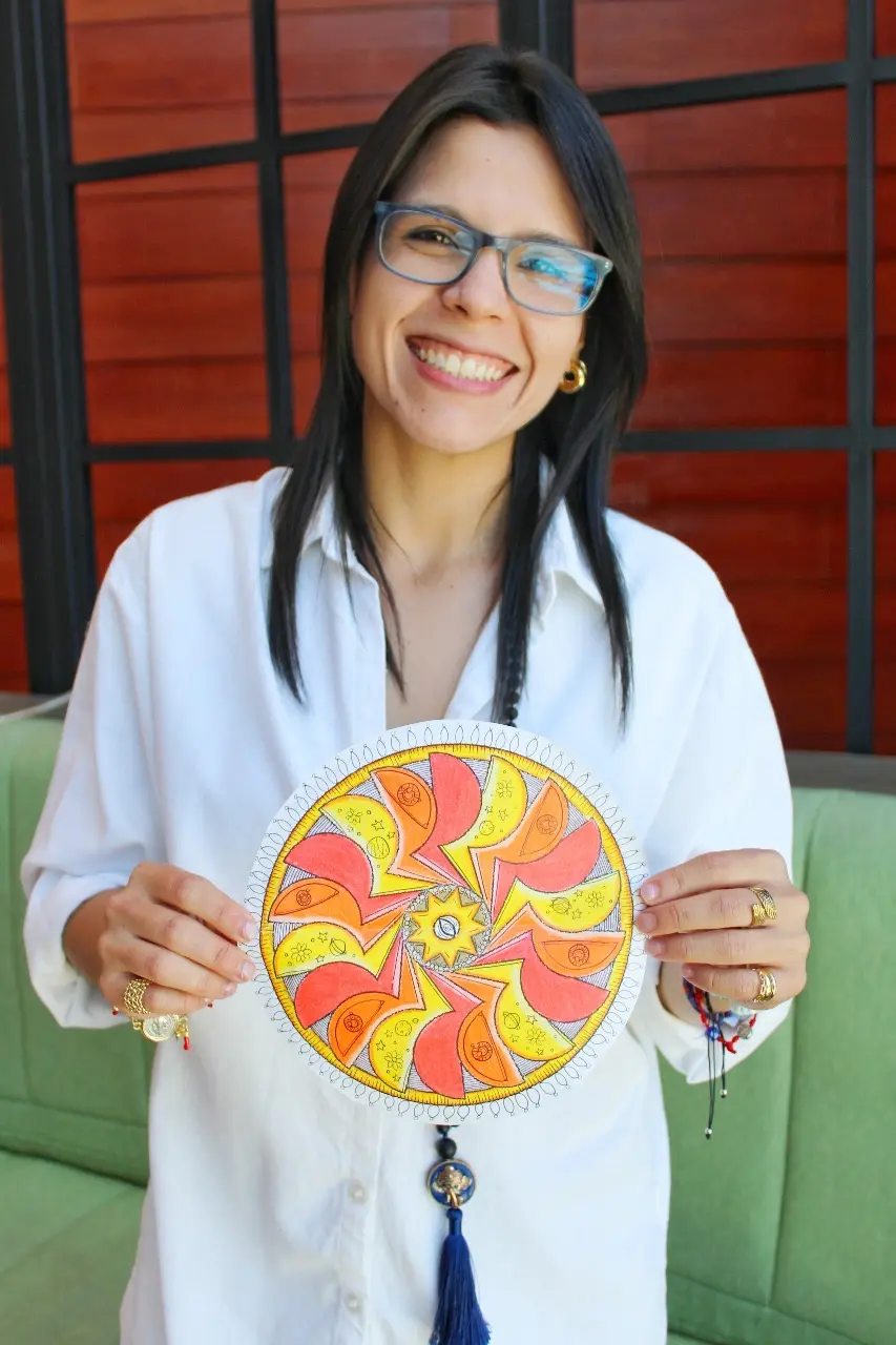 Gaby sostiene una ilustración circular de colores vivos